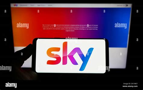 Person Holding Smartphone With Logo Of British Media Company Sky Group