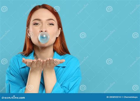 Beautiful Woman Blowing Bubble Gum On Turquoise Background Space For