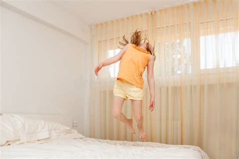 L Enfant Sautant Sur Le Lit Dans La Chambre Coucher Image Stock