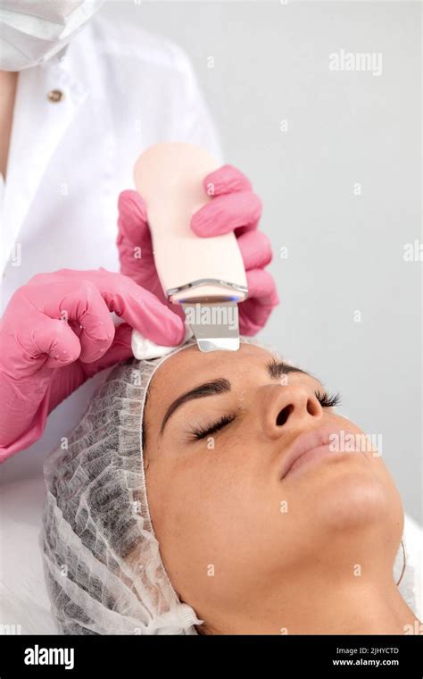 Cosmetologist Beautician In Pink Gloves Making Facial Treatment With