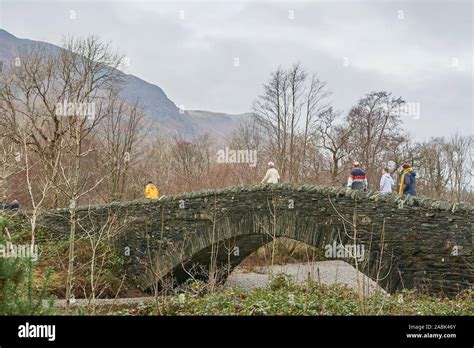 Ramblers Cross The Dry Stone Bridge Over The River Derwent At The