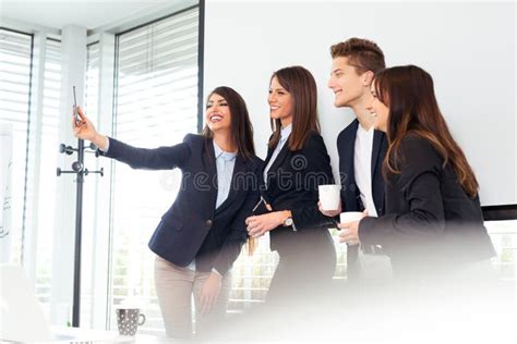 Group Of Business People Taking Selfie And Looking At Mobile Phone