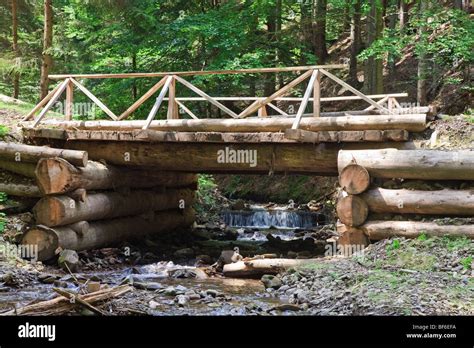 A Wooden Bridge Through Mountain Stream In Forest Stock Photo Alamy