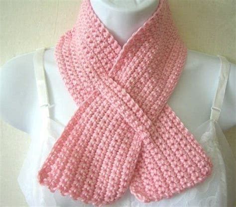 A Pink Knitted Scarf Sitting On Top Of A White Mannequin