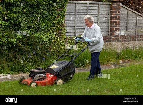 Senior Woman Mowing A Lawn With A Petrol Lawn Mower Stock Photo Alamy