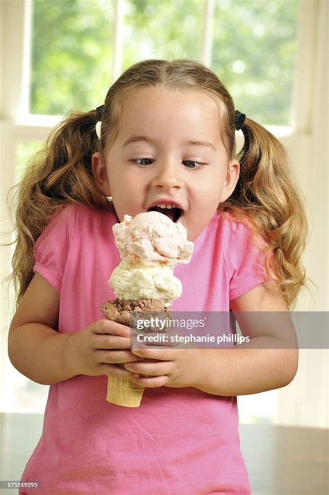 Cute Young Girl Eating A Triple Decker Ice Cream Cone High Res Stock