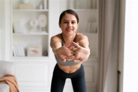 Mulher jovem em roupas esportivas se exercitando em casa Foto Grátis