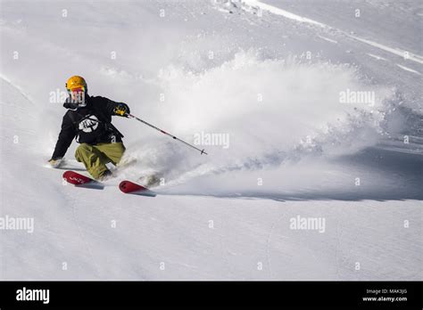 A Man Skis Off Piste On A Sunny Day In The French Alpine Resort Of