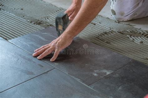 Worker Placing Ceramic Floor Tiles On Adhesive Surface Stock Photo