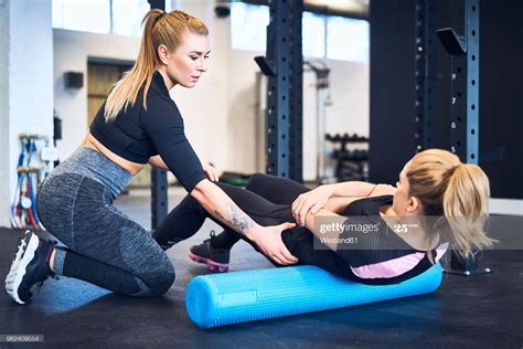 Woman Massages Muscles With Personal Trainer After Gym Workout