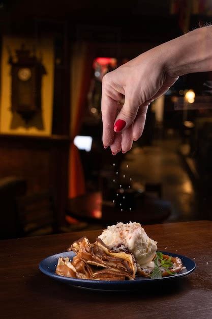 Premium Photo Female Hand Putting The Finishing Touch On Desserts