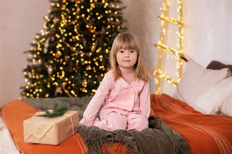 Joyeuse Petite Fille Souriante En Pyjama Avec Un Cadeau à La Veille De