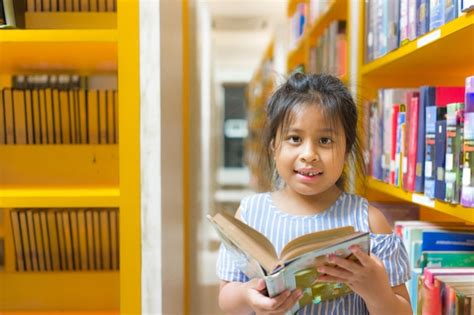 Premium Photo Portrait Of Girl Holding Book In Library