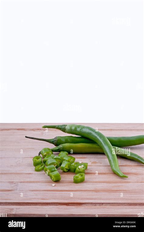 Chopped Green Chillies With Pile Of Green Chillies On Aged Chopping