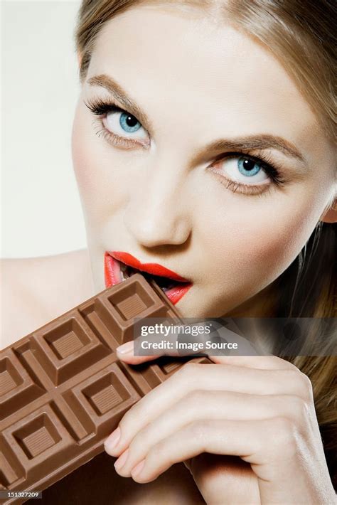 Young Woman Biting Chocolate High Res Stock Photo Getty Images