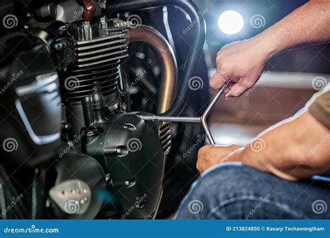 Mechanic Repairing Motorcycle Using Wrench Or Socket On The Engine Of