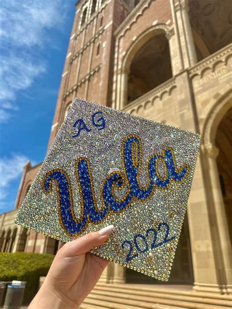 UCLA Grad Cap Bedazzled With Iridescent Gold And Blue Gems Held In