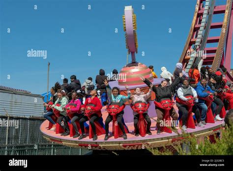 Young Women Enjoy The Electro Spin Ride In Luna Park On An Early Spring