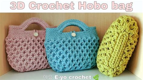 Three Crochet Hobo Bags Sitting Next To Each Other On Top Of A Shelf