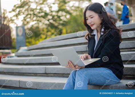 Asian Businesswoman With Laptop Computer Working Outside Looking At