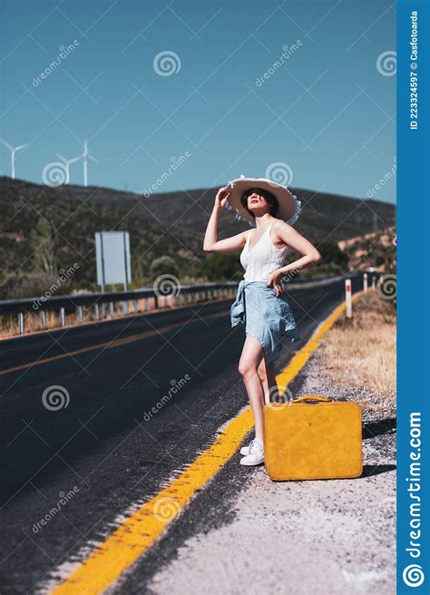 20s Age One Woman With A Straw Hat Hitchhiking By The Country Roadside