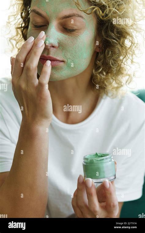 Beautiful Woman Applying Exfoliating And Cleansing Mask On Her Face