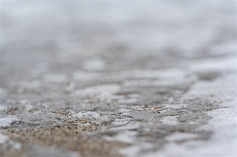 Macro Ground Level Closeup View Of Rock Salt Ice Melt On Concrete With