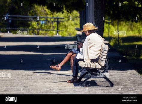 Vieille Dame Assise Sur Un Banc En Bois Banque De Photographies Et D