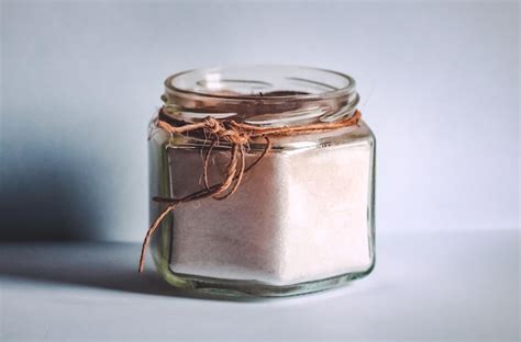 Premium Photo Glass Container With Sugar On White Background