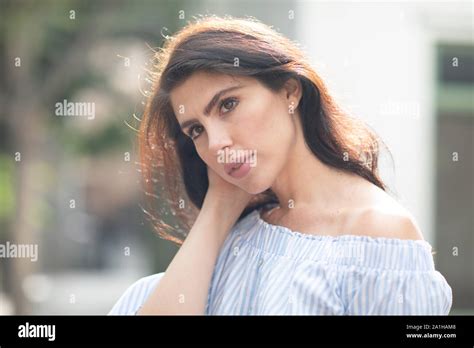 Shy But Flirty Brunette Tucking Her Hair Behind Her Ear Closeup Sunny Warm Day Stock Photo Alamy