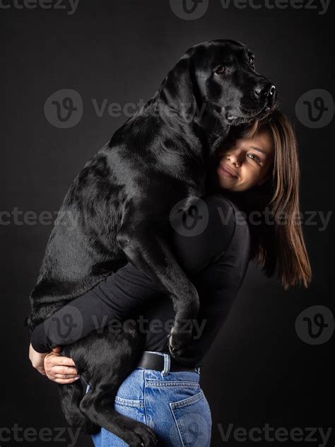 Une Fille Tient Un Chien Labrador Retriever Dans Ses Bras 15143711