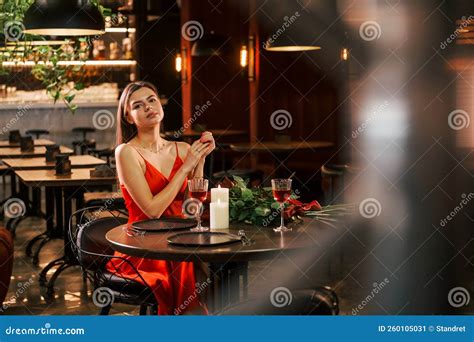 Woman In Red Dress Sitting Alone In The Restaurant Flowers And Candles Stock Image Image Of