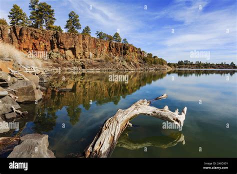 The calm waters of Fool Hollow Lake reflect the cliffs and sky. (Fool ...