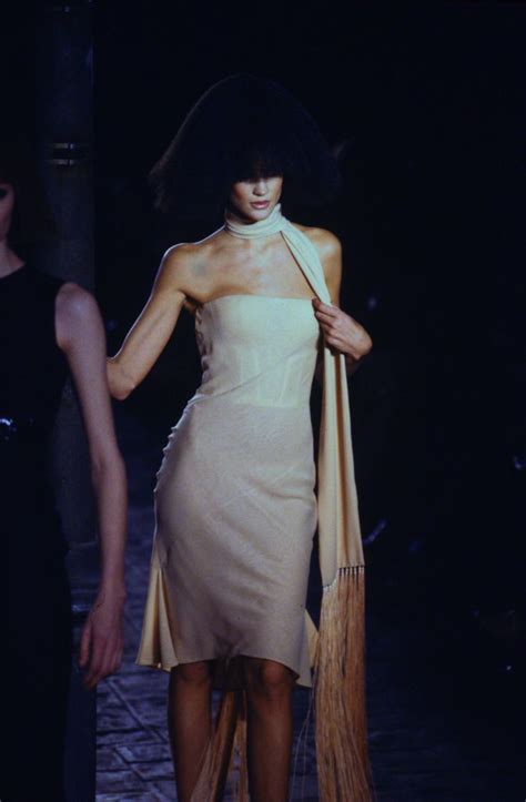 A Woman Walking Down A Runway In A Dress