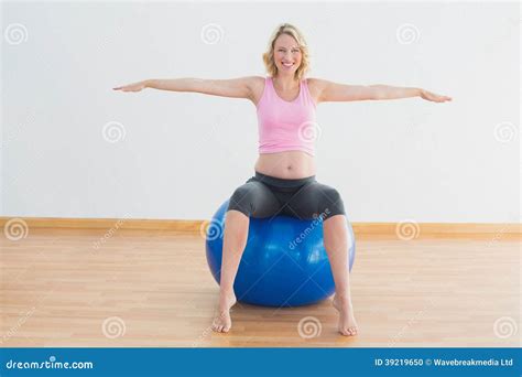 Smiling Blonde Pregnant Woman Sitting On Exercise Ball Stock Photo