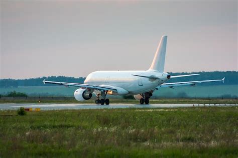 Avión de pasajeros blanco rodando hacia la pista Foto Premium