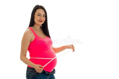 Portrait Of Pregnant Brunette In Pink Shirt Measure Her Belly With Tape And Posing On Camera