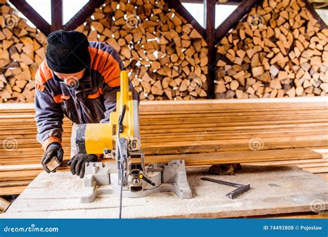 Carpenter Working Man Cutting Plank By Circular Saw Stock Photo