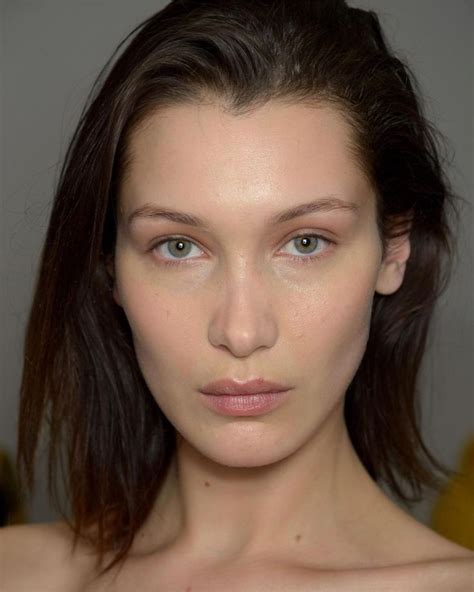 A Woman With Brown Hair And Blue Eyes Is Looking At The Camera While