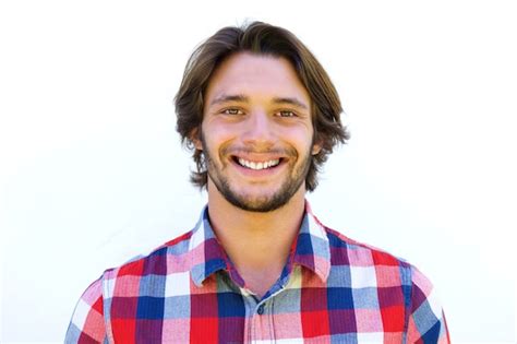 Sonriente Joven Con Barba De Pie Contra El Fondo Blanco Foto Premium