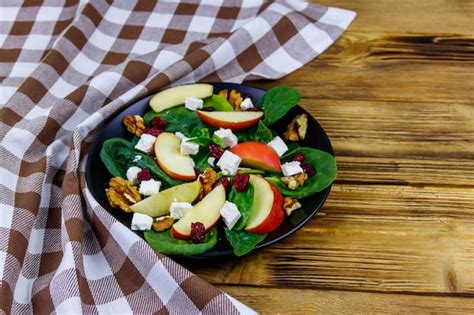 Premium Photo Autumn Spinach Salad With Apple Feta Cheese Walnut And Dried Cranberry On Wooden