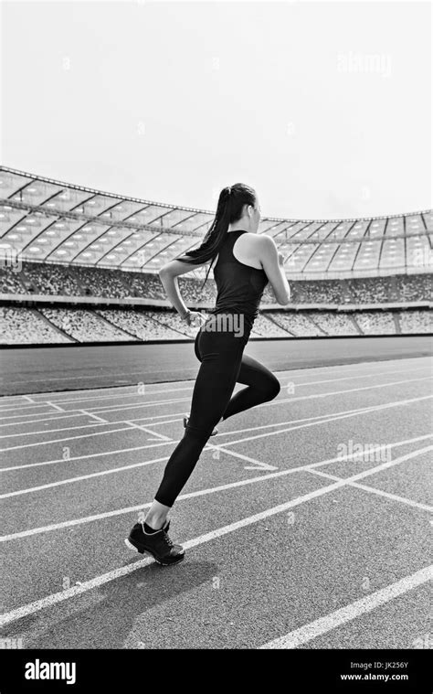 Young Fitness Woman In Sportswear Running On Running Track Stadium