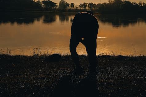 Silueta De Un Corredor Corriendo En La Playa Al Atardecer Con El Sol En