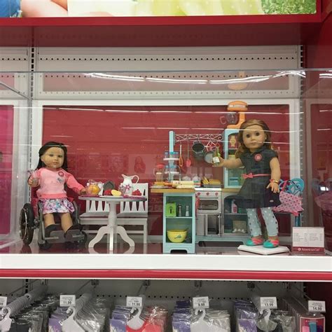 Two Dolls Are Sitting At A Table In A Toy Store