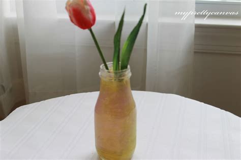 Two Tulips In A Vase Sitting On A Table