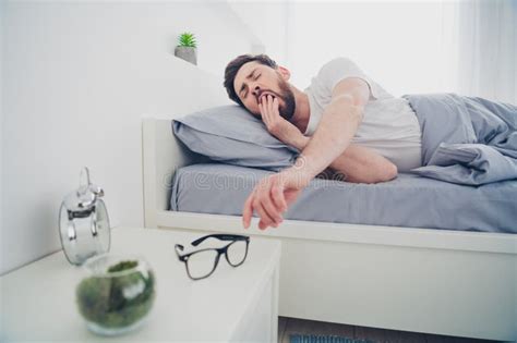 Photo Of Tired Funny Mature Guy Sleepwear Pajama Lying Bed Yawning Indoors Home House Bedroom