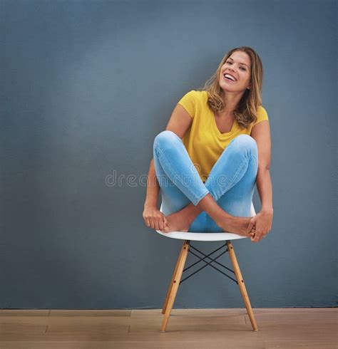 être Heureux Et Sourire Une Jeune Femme Assise Sur Une Chaise Contre