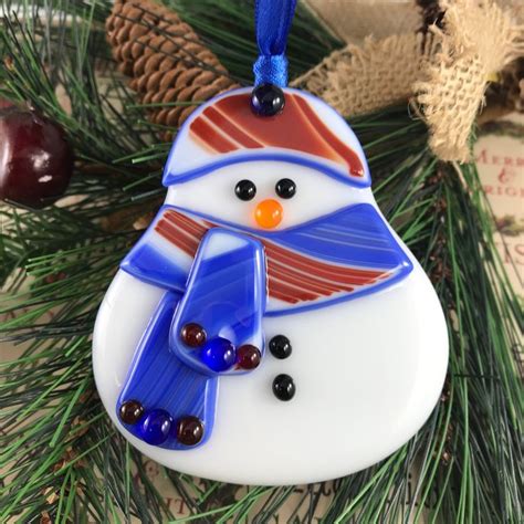 A Snowman Ornament Hanging From A Christmas Tree