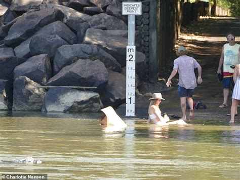 Gái xinh mặc bikini ngồi thả dáng trong nước sông đầy cá sấu