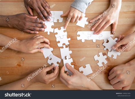 Close Multiracial People Team Assembling Puzzle Stock Photo